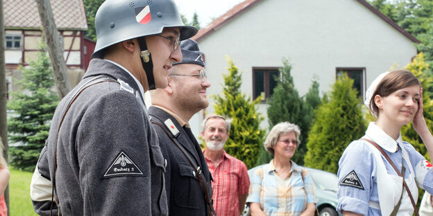 Ein Mann läuft bei einem Festumzug als Wehrmachtssoldat mit Ein Mann läuft bei einem Festumzug als Wehrmachtssoldat mit
