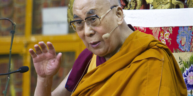 Ein Mann mit Brille und gelbem Gewand. Es ist der Dalai Lama Ein Mann mit Brille und gelbem Gewand. Es ist der Dalai Lama