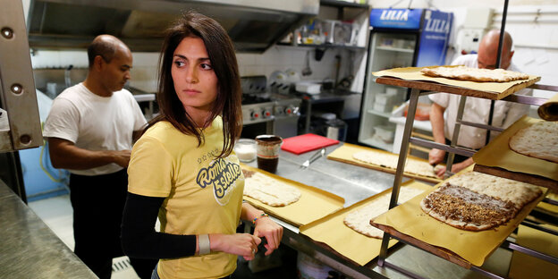 Virginia Raggi im gelben T-Shirt in der Küche einer Pizzeria Virginia Raggi im gelben T-Shirt in der Küche einer Pizzeria