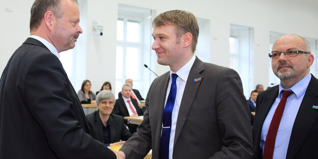 Daniel Rausch steht hinter André Poggenburg, als der Wulff Gallert die Hand schüttelt Daniel Rausch steht hinter André Poggenburg, als der Wulff Gallert die Hand schüttelt
