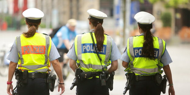 Drei Polizistinnen in Warnwesten von hinten Drei Polizistinnen in Warnwesten von hinten