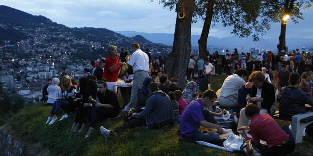 Menschen picknicken unter Bäumen mit Blick auf Sarajevo Menschen picknicken unter Bäumen mit Blick auf Sarajevo