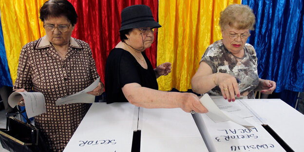 Frauen werfen ihren Stimmzettel in die Wahlurne. Frauen werfen ihren Stimmzettel in die Wahlurne.