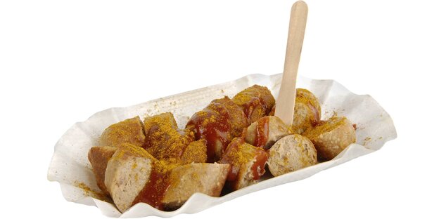 Eine fachgerecht zerstückelte Currywurst in einer Pappschale mit Pommesgabel Eine fachgerecht zerstückelte Currywurst in einer Pappschale mit Pommesgabel