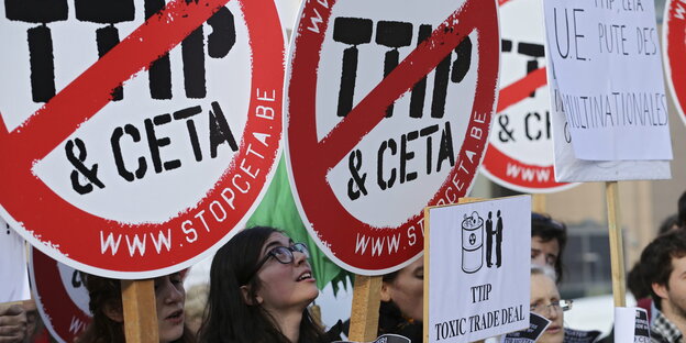 Demonstranten halten Schilder hoch, die sich gegen TTIP und Ceta aussprechen Demonstranten halten Schilder hoch, die sich gegen TTIP und Ceta aussprechen