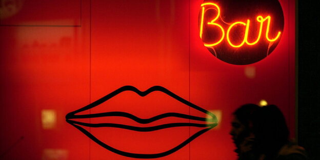 Die Fassade einer Erotik-Bar, die im rot beleuchteten Schaufenster mit übergroßen Lippen wirbt Die Fassade einer Erotik-Bar, die im rot beleuchteten Schaufenster mit übergroßen Lippen wirbt