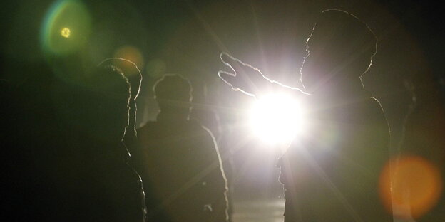 Ein Polizist zeigt tunesischen Flüchtlingen auf Lampedusa den Weg Ein Polizist zeigt tunesischen Flüchtlingen auf Lampedusa den Weg