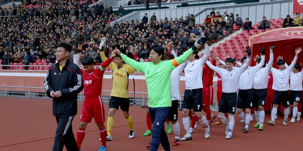 Fußballspieler laufen in eine Stadion ein