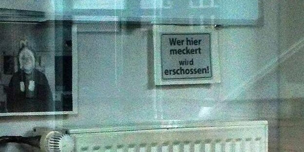 Ein Schild mit der Aufschrift: "Wer meckert, wird erschossen." Ein Schild mit der Aufschrift: "Wer meckert, wird erschossen."