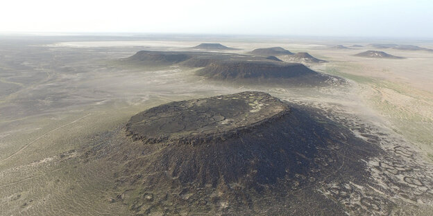 ein steinener Hügel in staubiger Landschaft