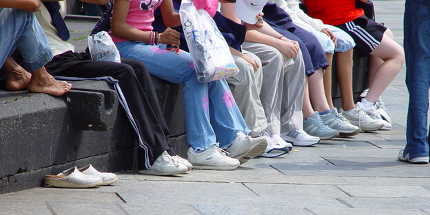Kinder/Jugendliche sitzen auf einer Steinbank Kinder/Jugendliche sitzen auf einer Steinbank