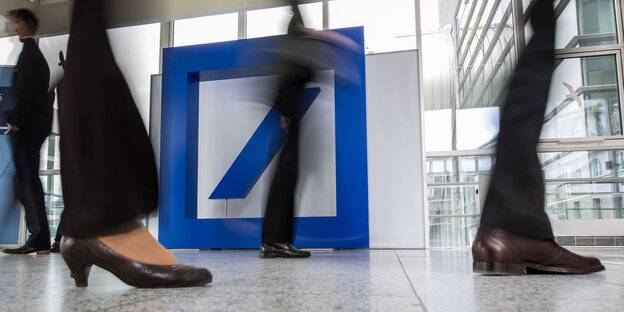 Beine vor einem Deutsche-Bank-Logo Beine vor einem Deutsche-Bank-Logo