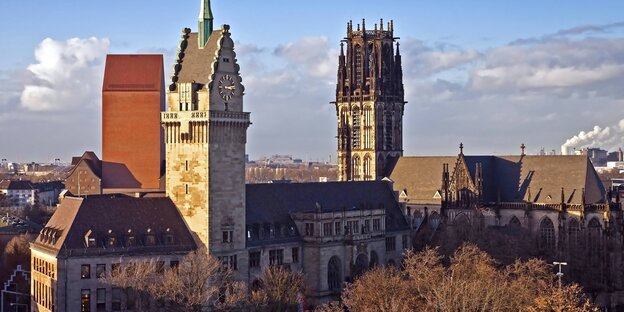 Duisburgs Rathaus im Vordergrund, im Hintergrund ein Kirchturm vor blauem Himmel Duisburgs Rathaus im Vordergrund, im Hintergrund ein Kirchturm vor blauem Himmel