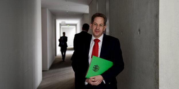 Hans-Georg Maaßen steht in einem halbdunklen Flur, hinter ihm bewegen sich dunkle Gestalten Hans-Georg Maaßen steht in einem halbdunklen Flur, hinter ihm bewegen sich dunkle Gestalten