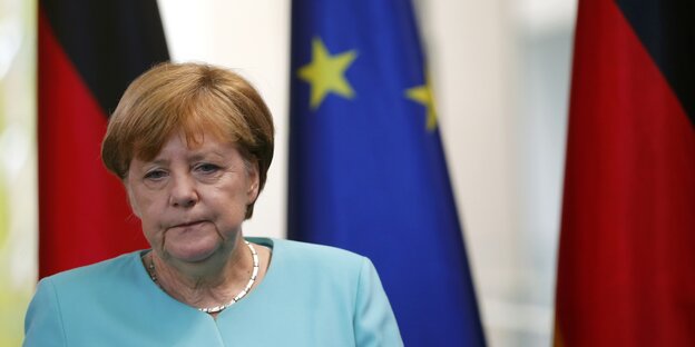 Angela Merkel blickt bedrückt nach unten Angela Merkel blickt bedrückt nach unten