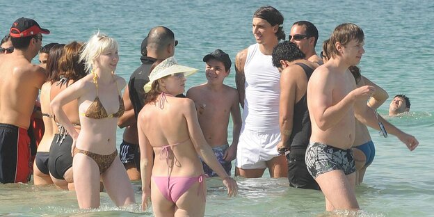 Zlatan Ibrahimoviic am Strand, umgeben von Menschen Zlatan Ibrahimoviic am Strand, umgeben von Menschen