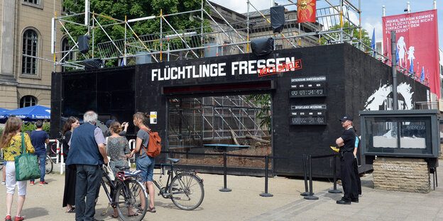 Besucher betrachten den Tigerkäfig vor dem Gorki-Theater in Berlin-Mitte, der zur Kunstaktion "Flüchtlinge fressen" gehört Besucher betrachten den Tigerkäfig vor dem Gorki-Theater in Berlin-Mitte, der zur Kunstaktion "Flüchtlinge fressen" gehört