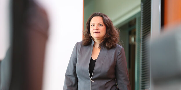 Andrea Nahles, eine Frau mit dunklen Haaren, trägt einen grauen Anzug und betritt einen Raum Andrea Nahles, eine Frau mit dunklen Haaren, trägt einen grauen Anzug und betritt einen Raum
