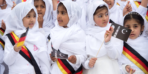 Mädchen mit Kopftüchern und Schärpen in Deutschlandfarben Mädchen mit Kopftüchern und Schärpen in Deutschlandfarben
