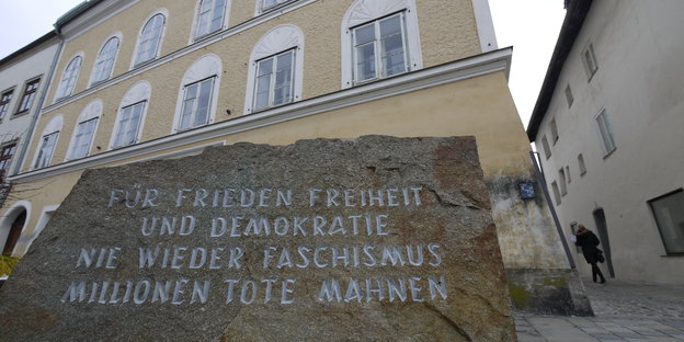 Ein Gedenkstein aus dem ehemaligen KZ Mauthausen vor Hitlers Geburtshaus in Braunau