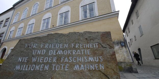 Ein Gedenkstein aus dem ehemaligen KZ Mauthausen vor Hitlers Geburtshaus in Braunau Ein Gedenkstein aus dem ehemaligen KZ Mauthausen vor Hitlers Geburtshaus in Braunau