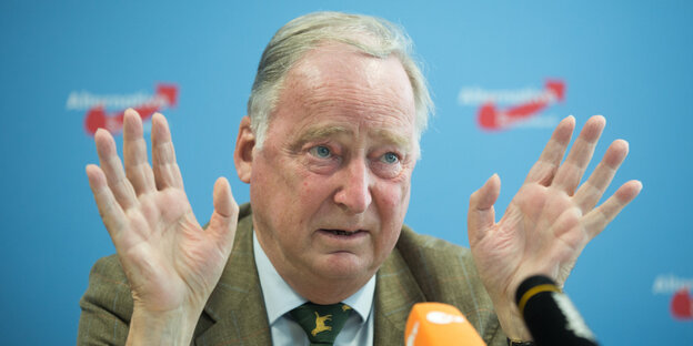 Alexander Gauland sitzt mit erhobenen Händen hinter einem Mikrofon Alexander Gauland sitzt mit erhobenen Händen hinter einem Mikrofon