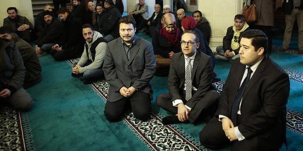Ender Cetin kniet neben Justizminister Heiko Maas in der Sehitlik-Moschee