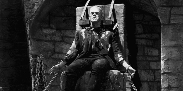Frankensteins Monster sitzt gefesselt auf einem Stuhl Frankensteins Monster sitzt gefesselt auf einem Stuhl