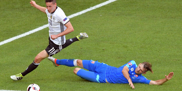 Julian Draxler dribbelt an seinem grätschenden Gegenspieler vorbei Julian Draxler dribbelt an seinem grätschenden Gegenspieler vorbei