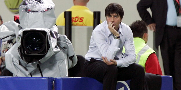 Joachim Löw blickt in die gleiche Richtung wie eine neben ihm stehende Kamera Joachim Löw blickt in die gleiche Richtung wie eine neben ihm stehende Kamera