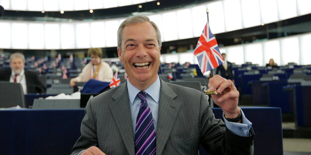 Ukip-Chef Nigel Farage hält im EU-Parlament lachend eine Großbritannienflagge hoch Ukip-Chef Nigel Farage hält im EU-Parlament lachend eine Großbritannienflagge hoch