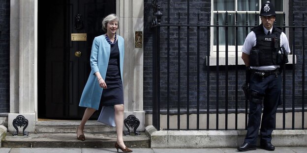 Die britische Innenministerin Theresa May verlässt 10 Downing Street, neben der Tür steht ein Bobby Die britische Innenministerin Theresa May verlässt 10 Downing Street, neben der Tür steht ein Bobby