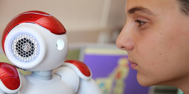 Roboter und Mensch gucken sich an Roboter und Mensch gucken sich an