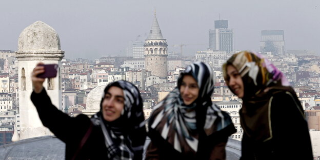 Drei Frauen machen Selfies vor dem Galata-Turm in Istanbul Drei Frauen machen Selfies vor dem Galata-Turm in Istanbul