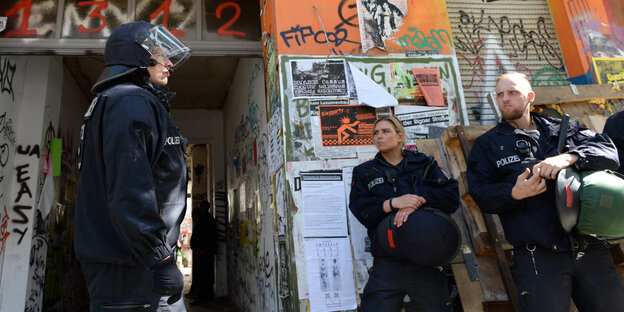 Polizisten stehen vor einem Hauseingang Polizisten stehen vor einem Hauseingang