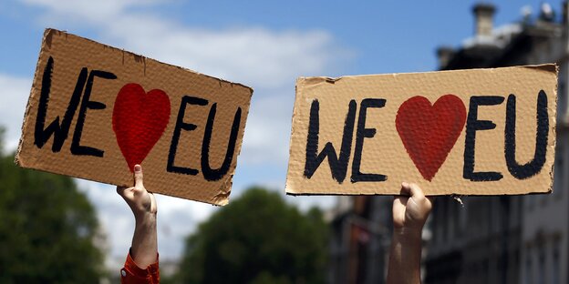 Protestierende halten Schilder hoch, auf denen „We love EU“ steht Protestierende halten Schilder hoch, auf denen „We love EU“ steht