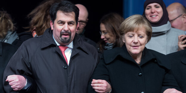 Bundeskanzlerin Angela Merkel und der Vorsitzende des Zentralrats der Muslime Aiman Mazyek Arm in Arm Bundeskanzlerin Angela Merkel und der Vorsitzende des Zentralrats der Muslime Aiman Mazyek Arm in Arm