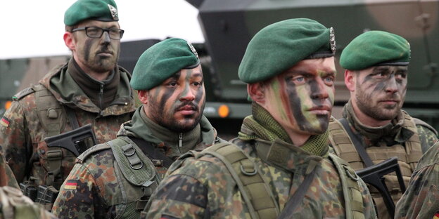 Soldaten stehen mit Tarnfarben im Gesicht Soldaten stehen mit Tarnfarben im Gesicht