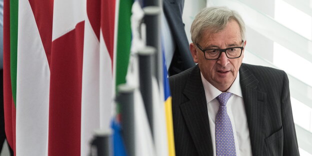 Jean-Claude Juncker läuft an Flaggen vorbei Jean-Claude Juncker läuft an Flaggen vorbei
