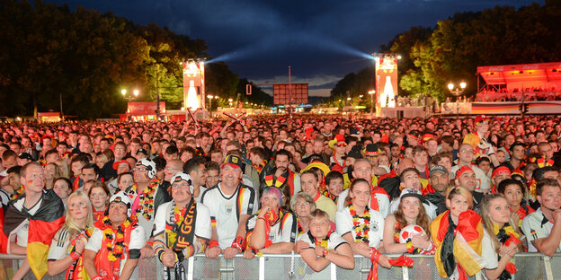 Viele Fans schauen Fußball in deutschland-farbenen Fan-Utensilien Viele Fans schauen Fußball in deutschland-farbenen Fan-Utensilien