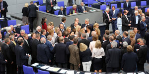 Parlamentarier stehen im Bundestag herum