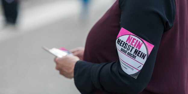 Eine Frau steht mit einer Armbinde mit der Aufschrift "Nein heißt Nein" vor dem Deutschen Bundestag Eine Frau steht mit einer Armbinde mit der Aufschrift "Nein heißt Nein" vor dem Deutschen Bundestag