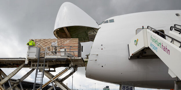 Ein Koffer fährt auf einem Laufband in den Frachtraum eines Flugzeugs Ein Koffer fährt auf einem Laufband in den Frachtraum eines Flugzeugs