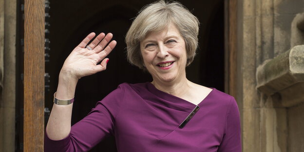 Theresa May winkt und lächelt Theresa May winkt und lächelt