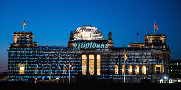 Der Bundestag wird von außen mit Text bestrahlt Der Bundestag wird von außen mit Text bestrahlt