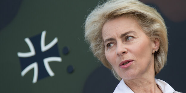 Ursula von der Leyen neben einem Fahrzeug mit einem Hoheitszeichen der Bundeswehr. Ursula von der Leyen neben einem Fahrzeug mit einem Hoheitszeichen der Bundeswehr.