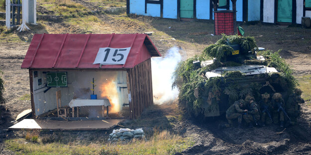 Bundeswehrsoldaten suchen Schutz hinter einem Panzer