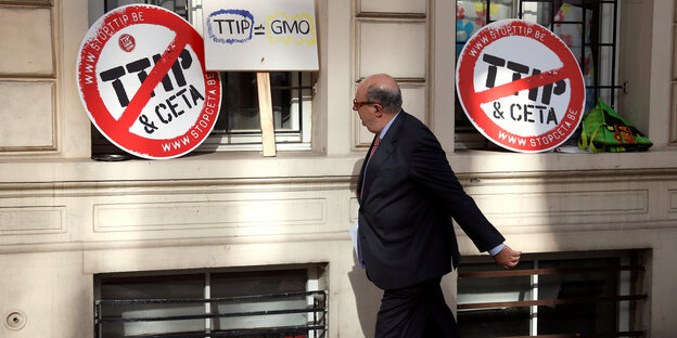 Ein Mann läuft an Schildern vorbei, die sich gegen TTIP und Ceta wenden Ein Mann läuft an Schildern vorbei, die sich gegen TTIP und Ceta wenden