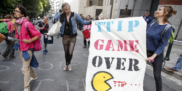 Einige Protestierende mit einem Transparent auf dem „TTIP Game Over“ steht Einige Protestierende mit einem Transparent auf dem „TTIP Game Over“ steht