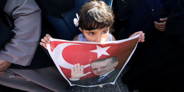 Ein kleines Mädchen hält ein Bild von Erdogan mit der türkischen Fahne hoch Ein kleines Mädchen hält ein Bild von Erdogan mit der türkischen Fahne hoch